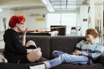 Kaksi nuorta juttelevat sohvalla.